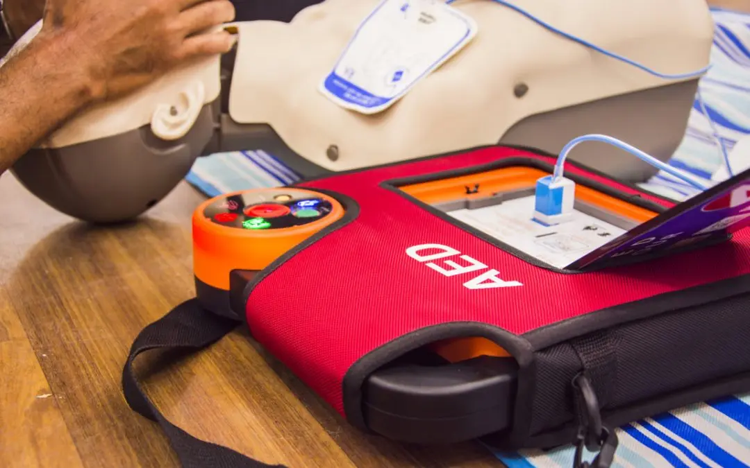 Desfibrilador Externo Automático (DEA) sobre superficie de oficina, equipo médico para áreas cardioasistidas